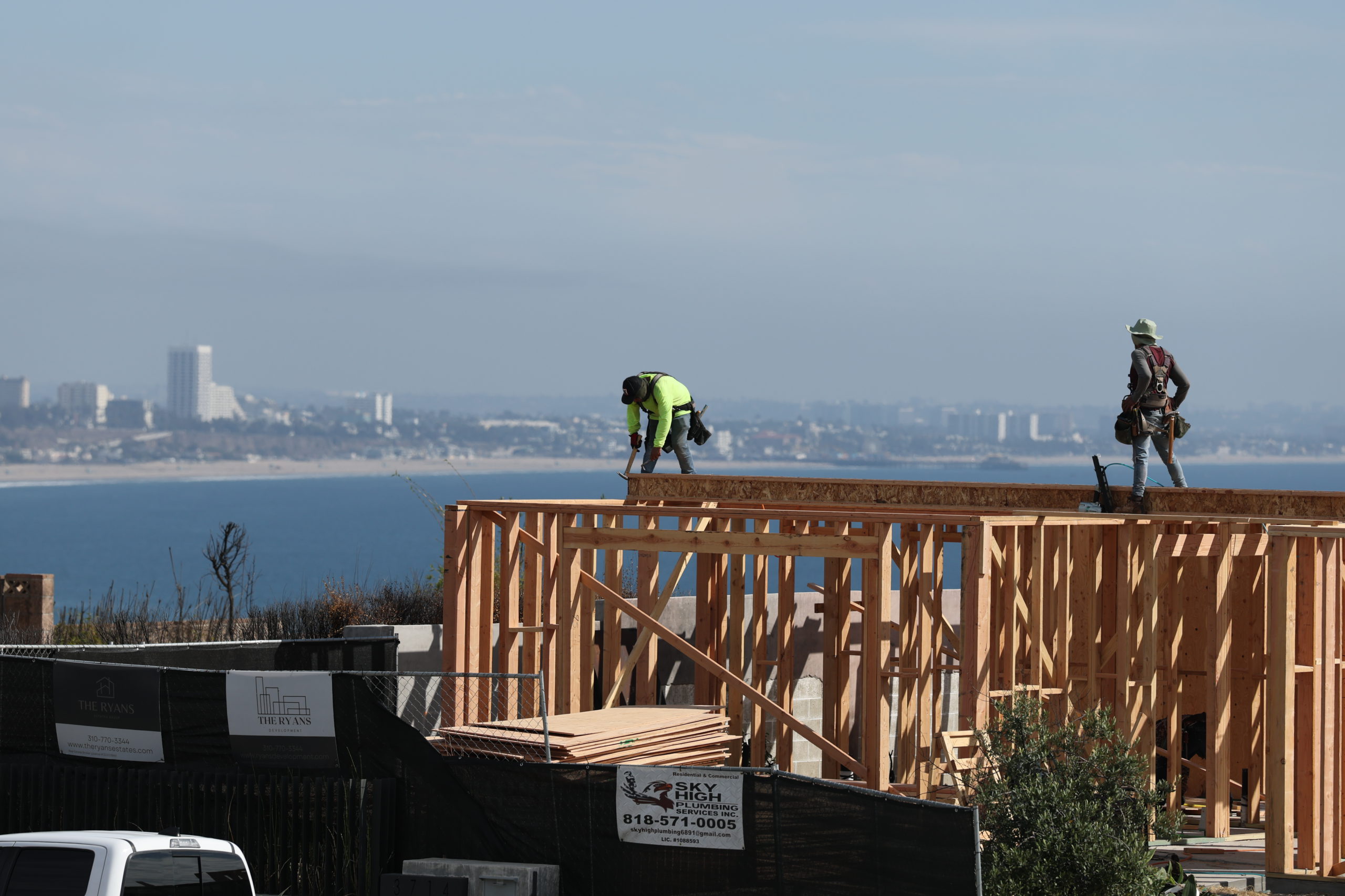 Construction workers stand atop home scaffolding in the Sunset Mesa neighborhood of eastern Malibu.