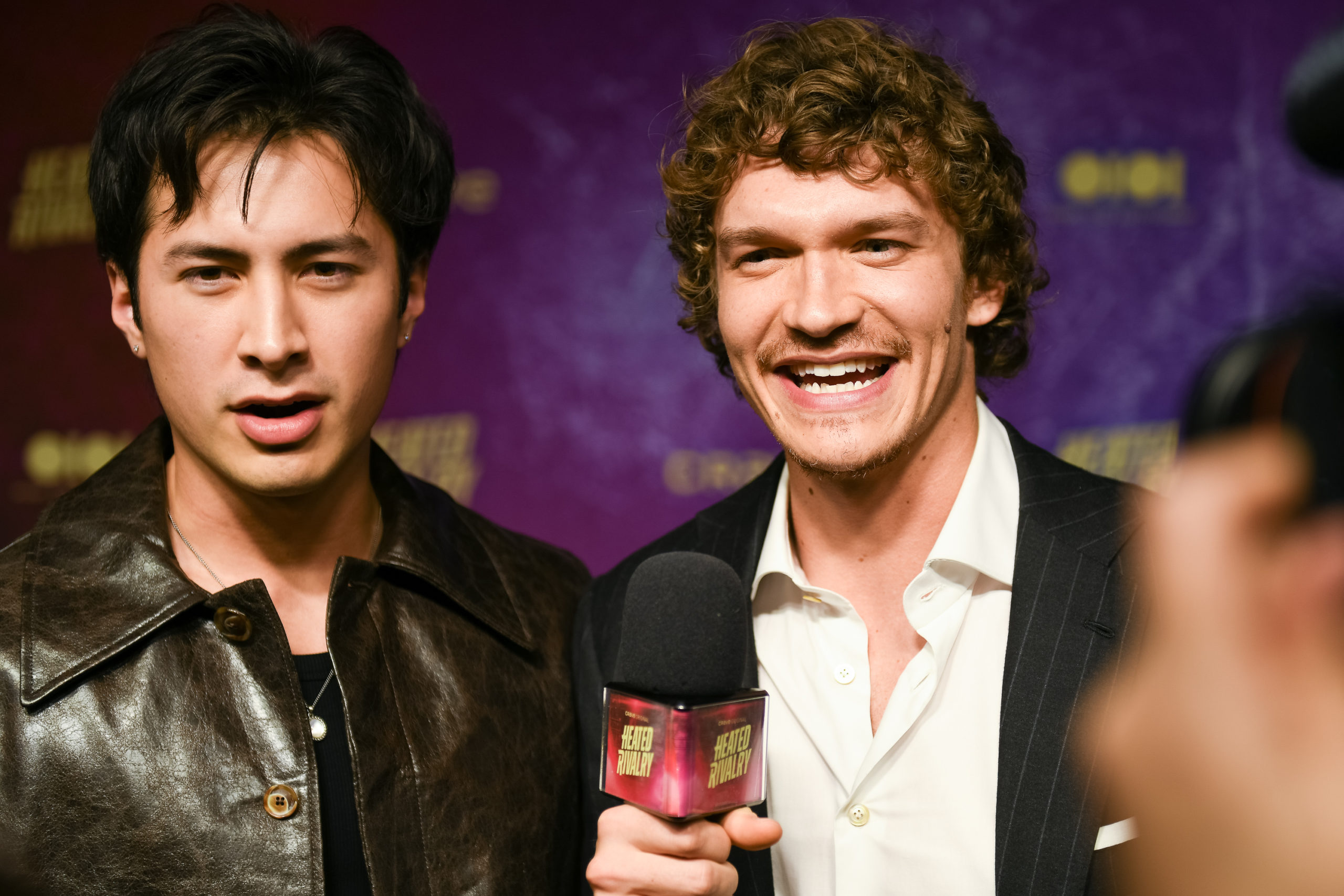 Hudson Williams and Connor Storrie speak into a microphone