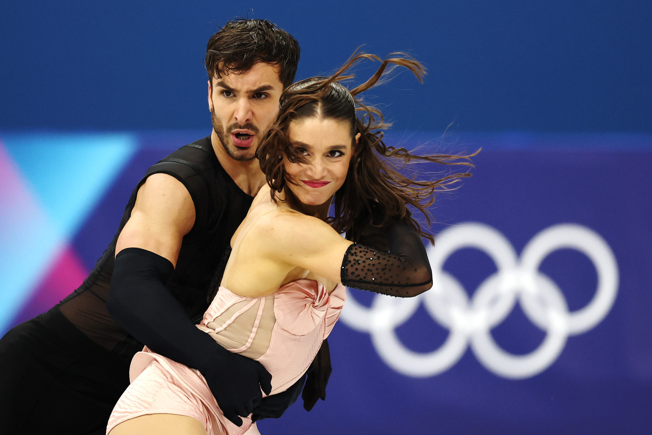 France’s Laurence Fournier Beaudry and Guillaume Cizeron skate as a pair with the Olympic rings behind them.