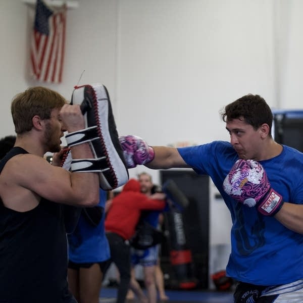 A man works out through boxing with a sparring partner.