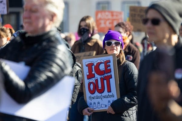 A woman in a crowd holds an 