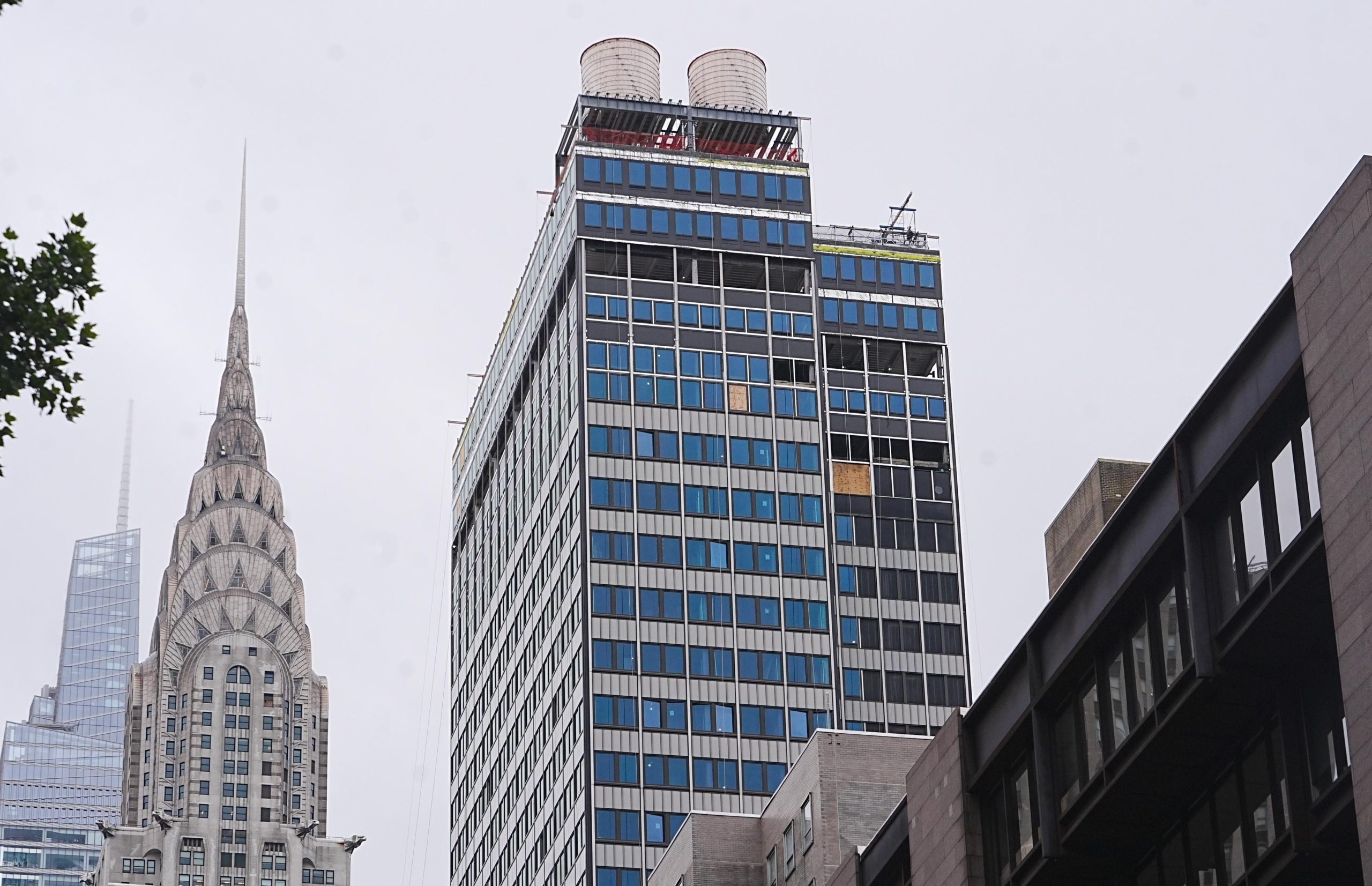 An offive tower under construction in Manhattan with the Chrysler building in the background