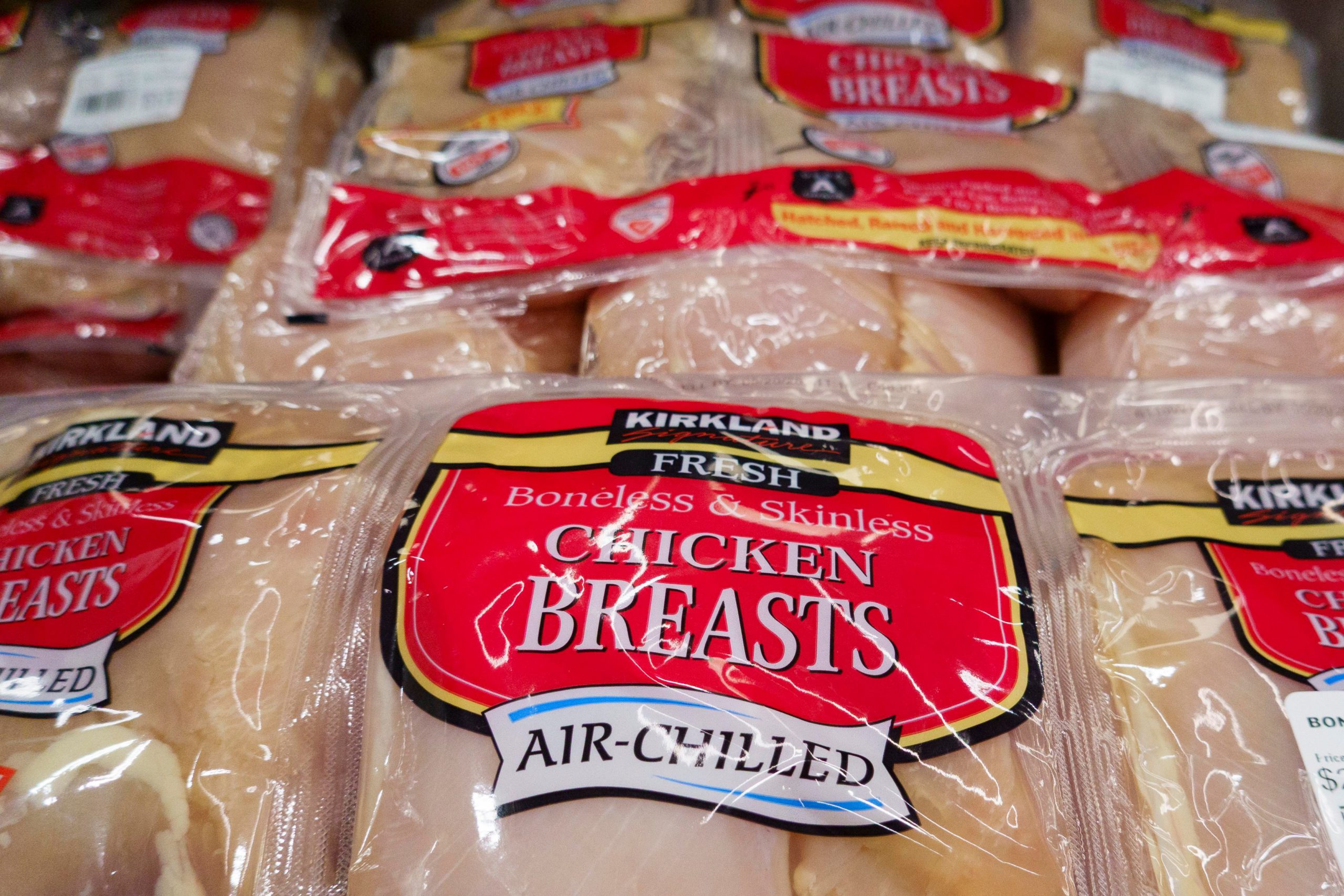 A close-up photograph of packages of Costco chicken breasts.