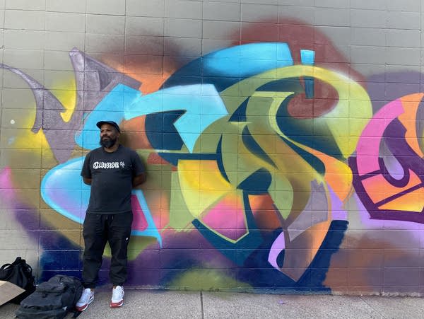 A person standing in front of a mural