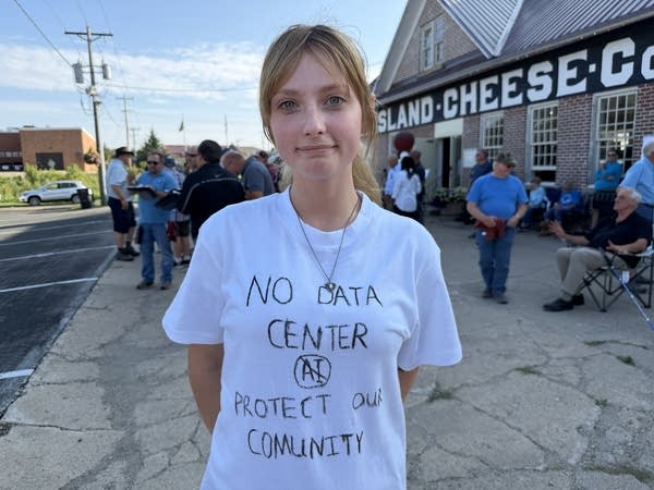 A woman wearing a white t-shirt with words written on it