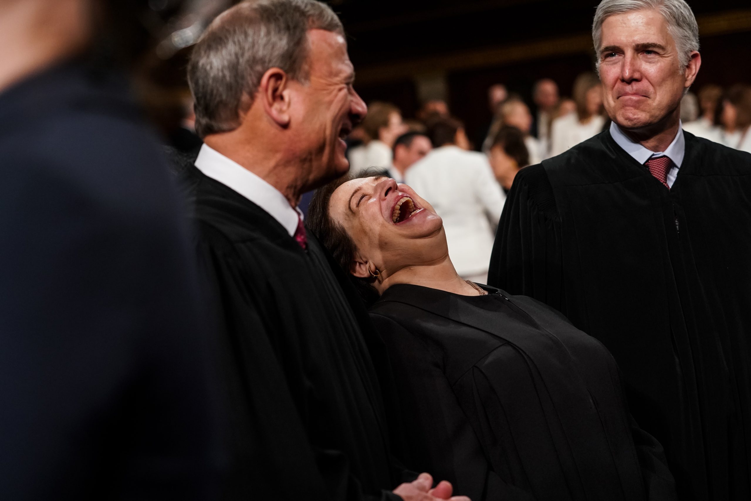 John Roberts, Elena Kagan, and Neil Gorsuch talk together. Kagan is laughing.