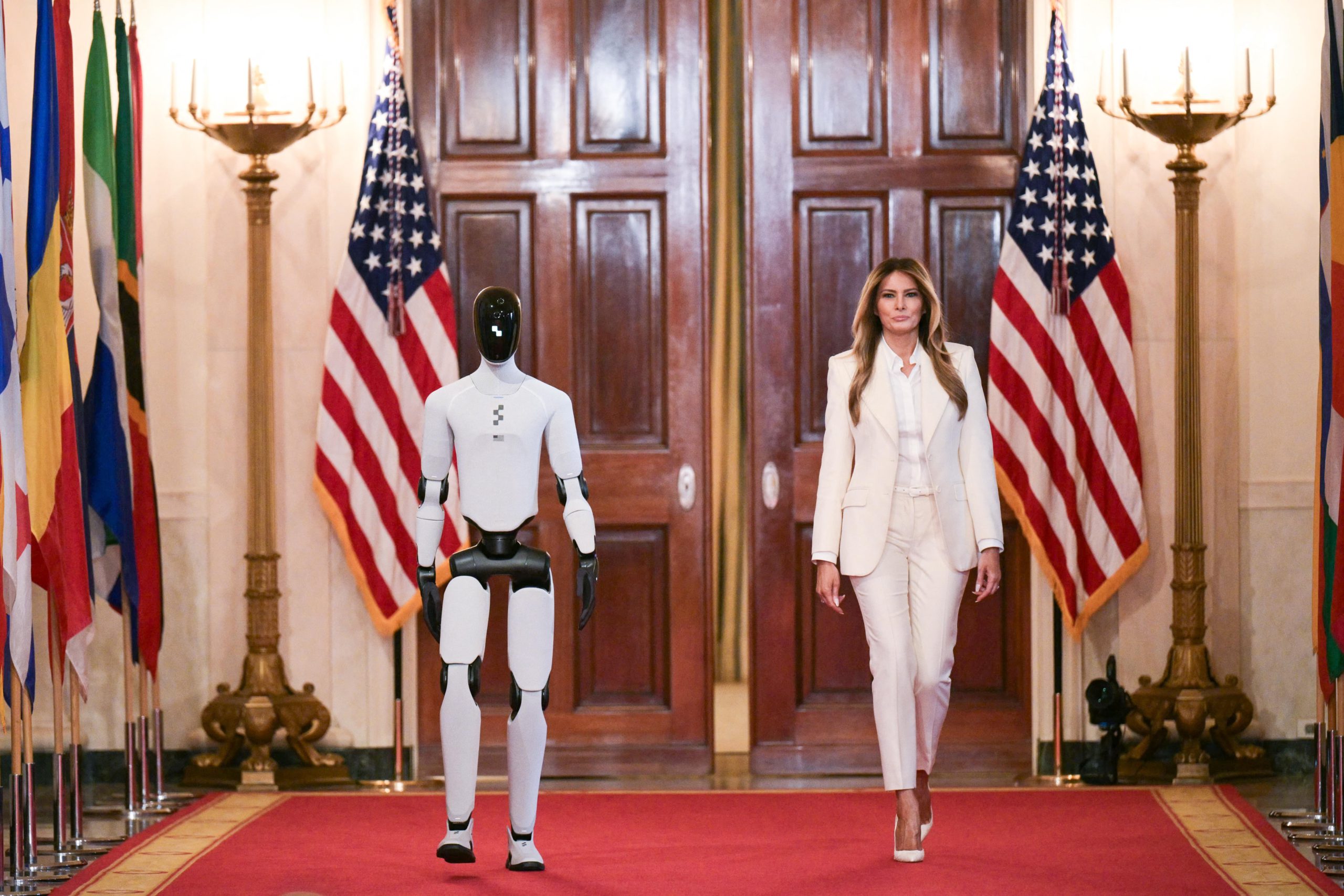 Melania Trump and a humanoid robot walk together