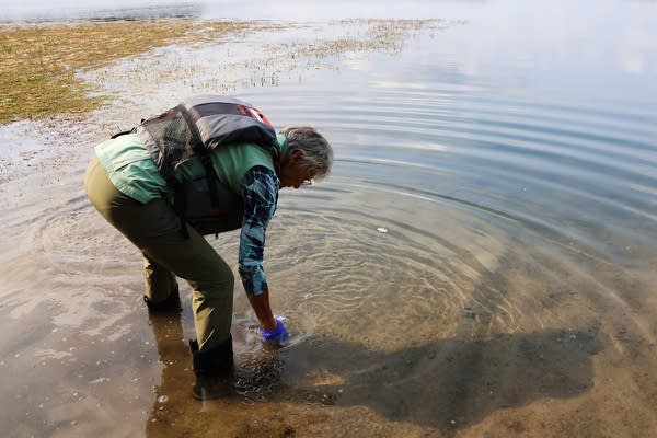 A woman collects a water sample