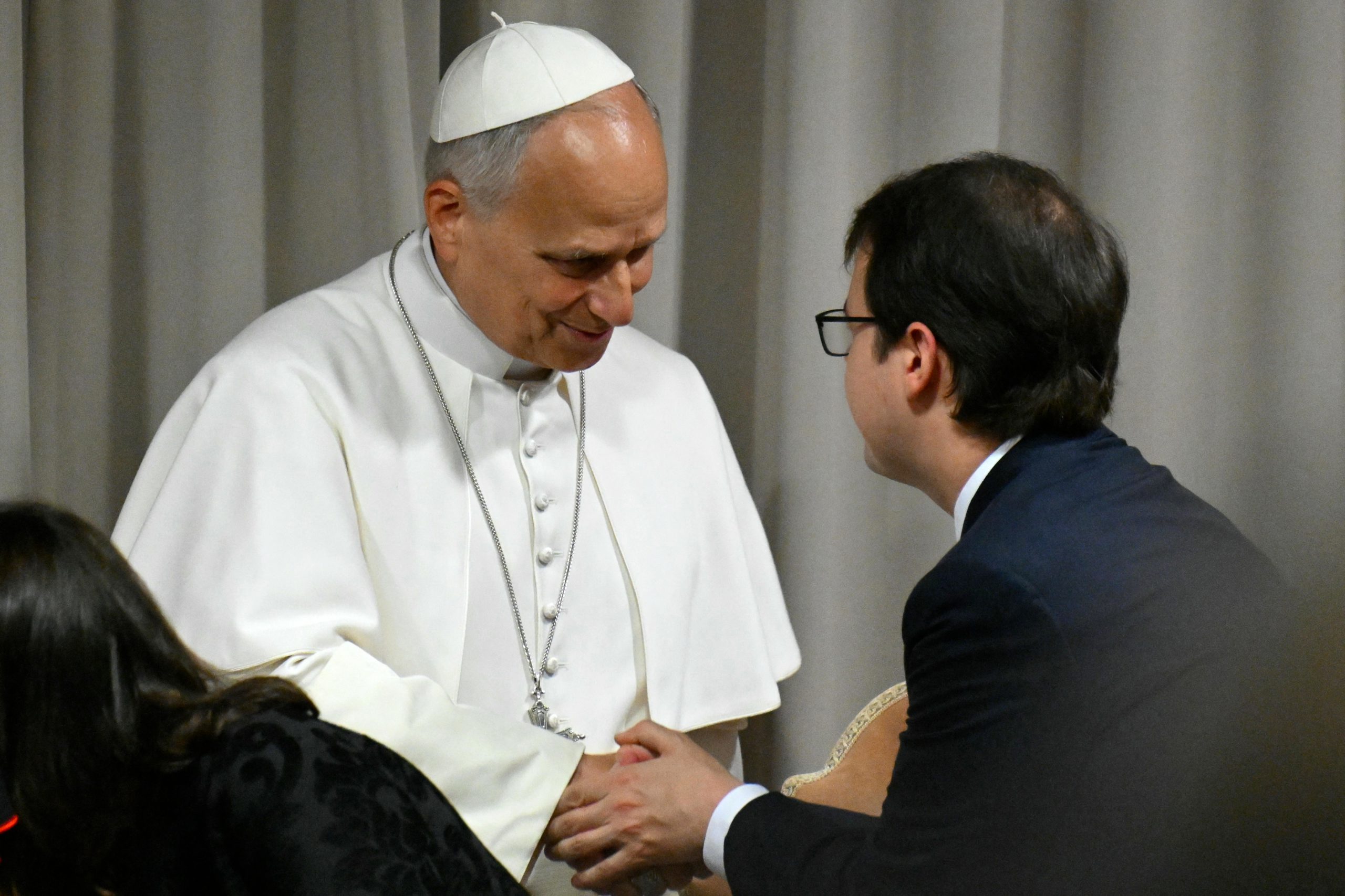 Anthropic’s Christopher Olah, a dark-haired, clean-shaven man in a suit, shakes hands with Pope Leo XIV.