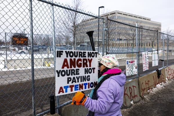 A protester holds a sign outside the Whipple Federal Building