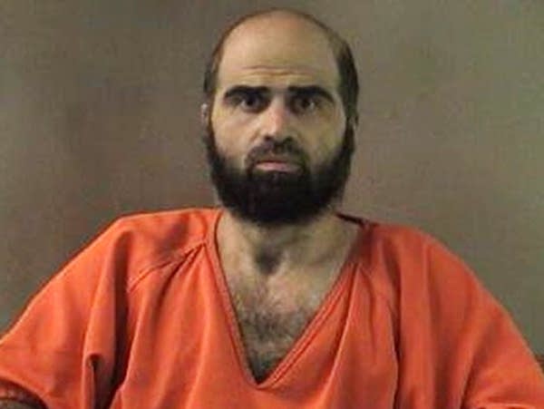 A grainy photo of a man in an orange prison jumpsuit.