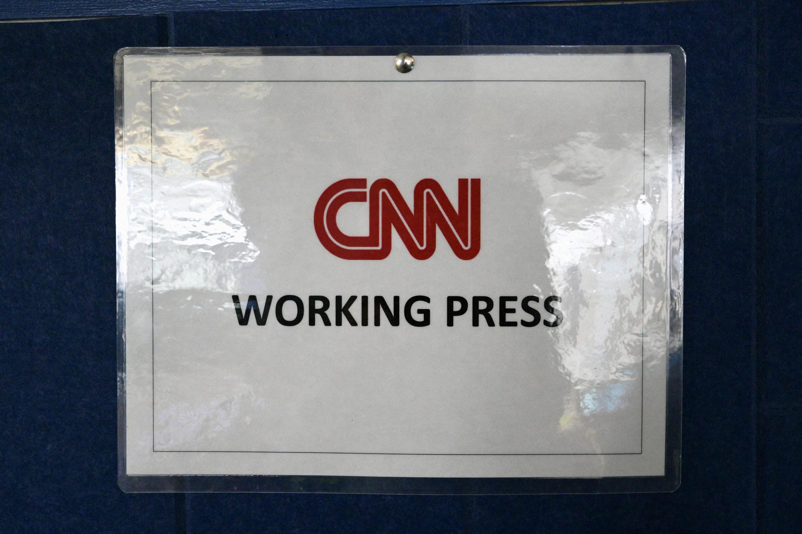 A white sign reads “CNN working press” in red and black text.