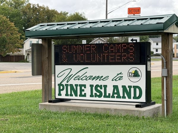 A green and white sign reads,