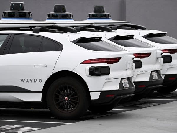 Three parked autonomous self-driving electric vehicles