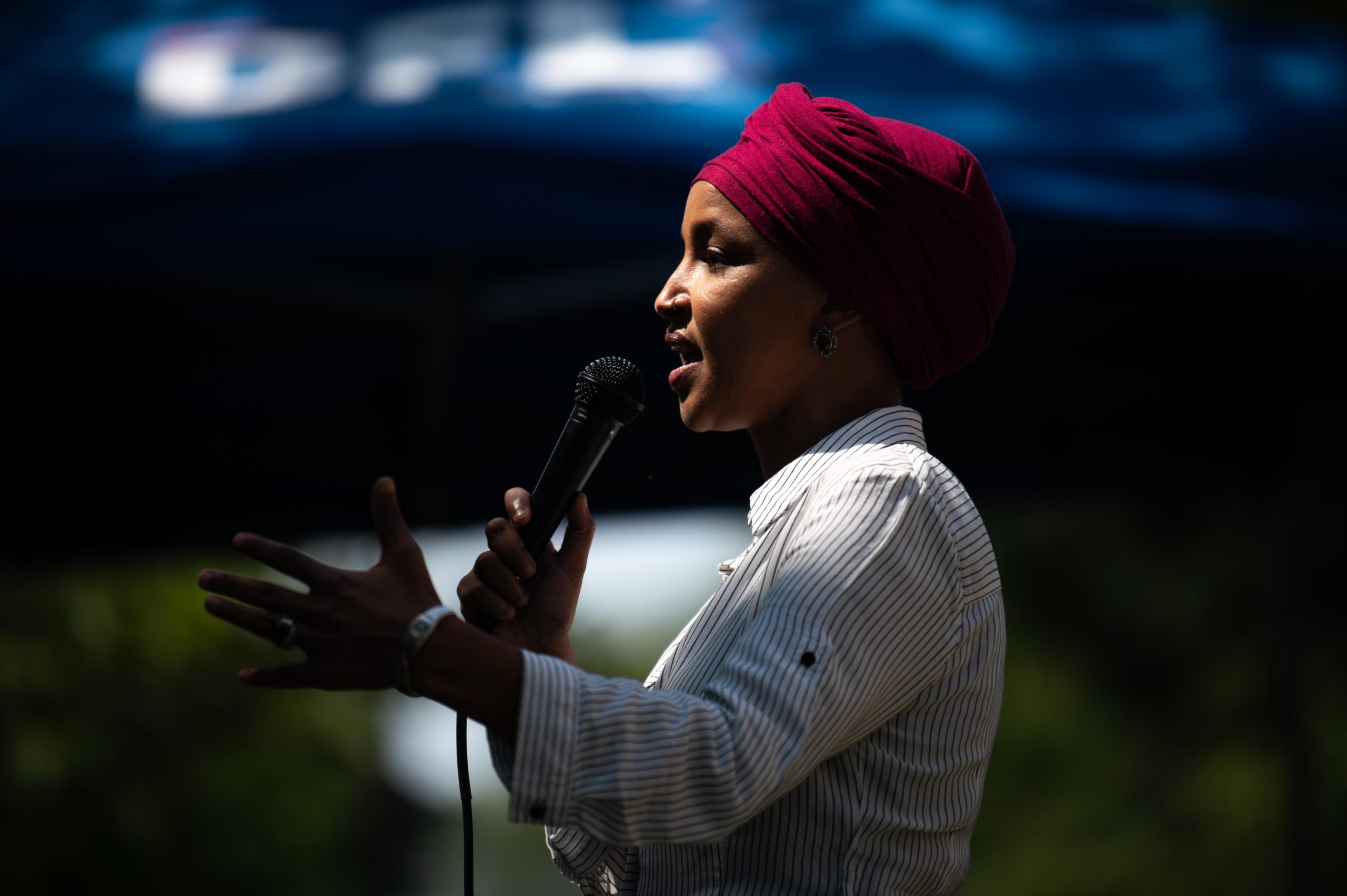 Ilhan Omar is onstage talking into a mic